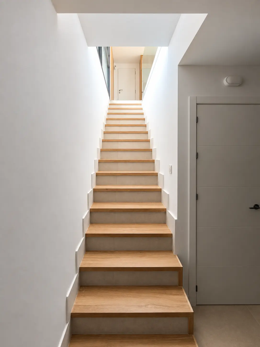 Escalera interior iluminada desde la planta superior